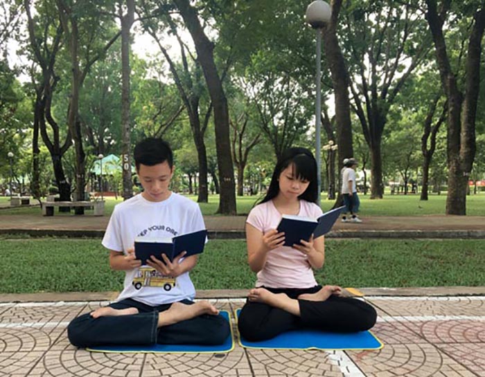 Hai con của cô Lánh đang đọc cuốn Chuyển Pháp Luân của Pháp Luân Công. Sau khi chứng kiến huyền năng của Phật Pháp, các em cũng bắt đầu chân chính bước chân vào tu luyện. (Ảnh tác do giả cung cấp)