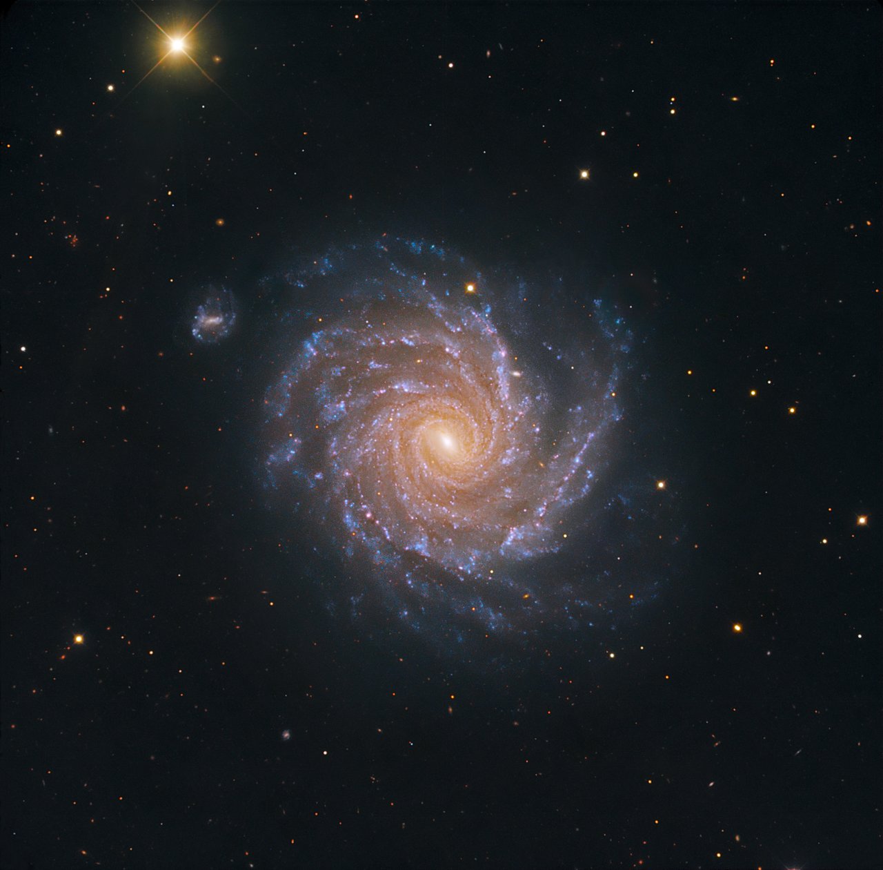 The striking, large spiral galaxy NGC 1232, and its distorted companion shaped like the greek letter "theta". The pair is located roughly 60 million light-years away in the constellation Eridanus (The River). Billions of stars and dark dust are caught up in this beautiful gravitational swirl. The blue spiral arms with their many young stars and star-forming regions make a striking contrast with the yellow-reddish core of older stars. This image is based on data acquired with the 1.5 m Danish telescope at the ESO La Silla Observatory in Chile, through three filters (B: 900 s, V: 400 s, R: 400 s).